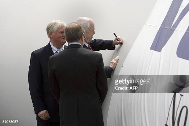 Senator John McCain signs the blade of a wind turbine at Vestas Wind Energy Training Facility as Vestas America President Jens Soby and Oregon...