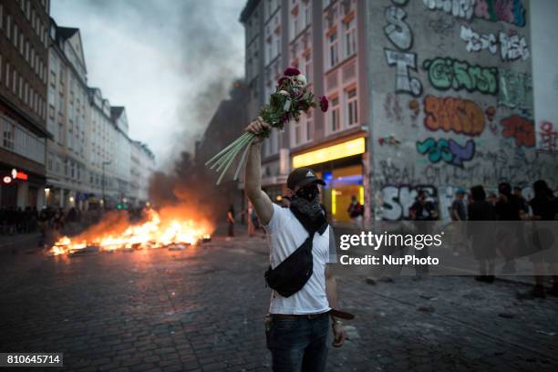 A demonstrator holds flowers during protests during the G20 summit in Hamburg, Germany, on July 7, 2017.