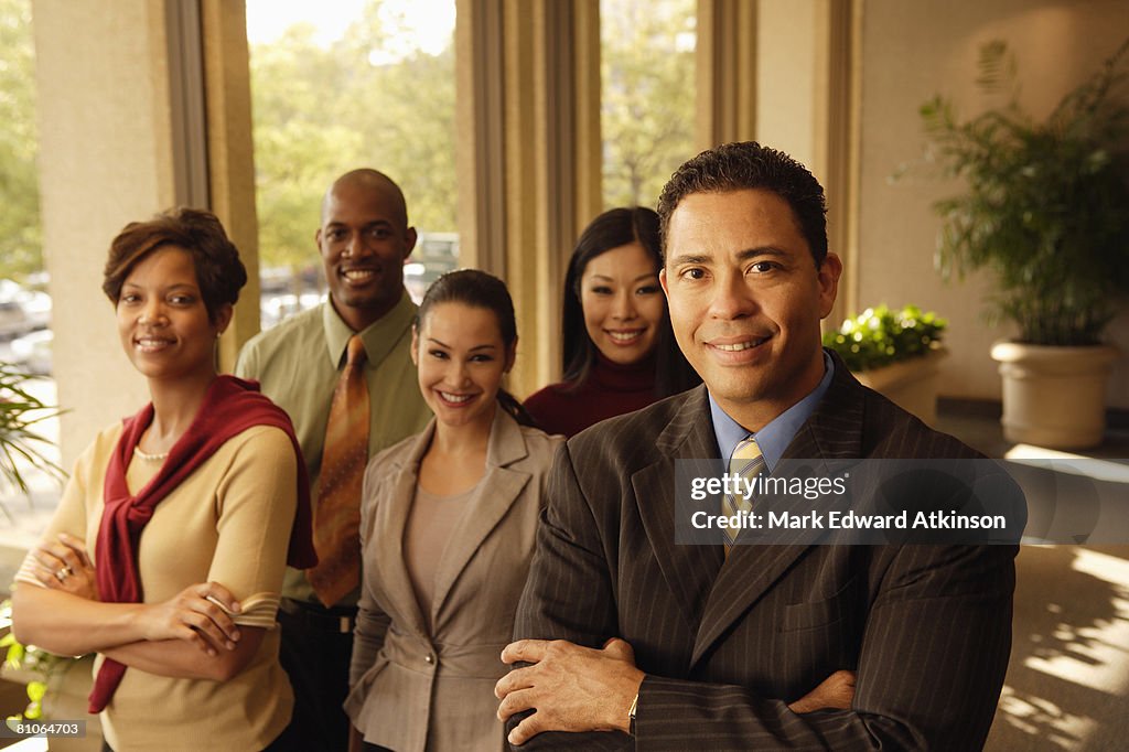 Hispanic businessman in front of coworkers