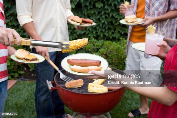 hispanic friends having barbecue - summer grilling stock pictures, royalty-free photos & images