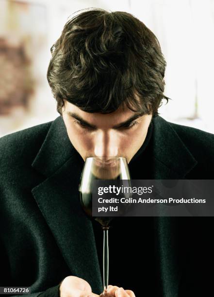 young man sniffing glass of wine - wine enjoyment stock pictures, royalty-free photos & images