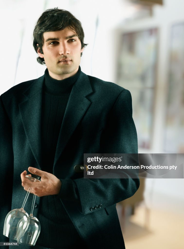 Young man holding wine glasses
