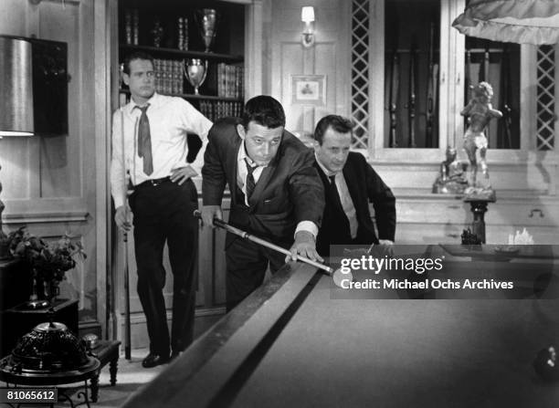 Paul Newman and George C. Scott look on as Murray Hamilton takes a shot in a scene from the 20th Century-Fox production of "The Hustler" in 1961 in...