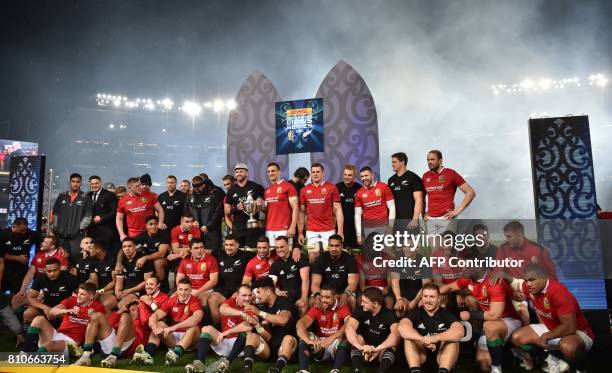 New Zealand's No 8 Kieran Read and British and Irish Lions blindside flanker Sam Warburton hold the trophy with their teammates after the drawn test...