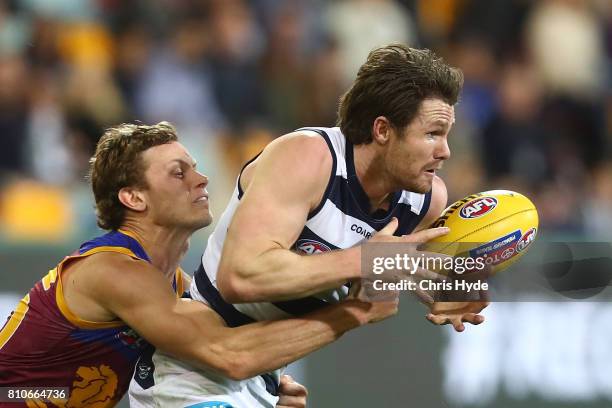 Patrick Dangerfield of the Cats is tackled by Ryan Lester of the Lions during the round 16 AFL match between the Brisbane Lions and the Geelong Cats...