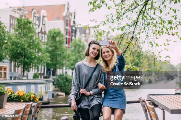selfie am fluss amstel - amsterdam stock-fotos und bilder