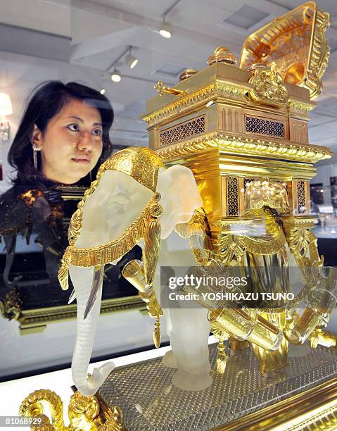 Japanese woman gazes at an elephant shaped liqueur tantalus, 66cm tall and weighing 57kg, made by French luxury crystal maker Baccarat, priced 63...