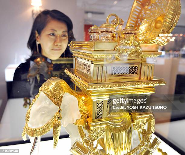 Japanese woman gazes at an elephant shaped liqueur tantalus, 66cm tall and weighing 57kg, made by French luxury crystal maker Baccarat, priced 63...