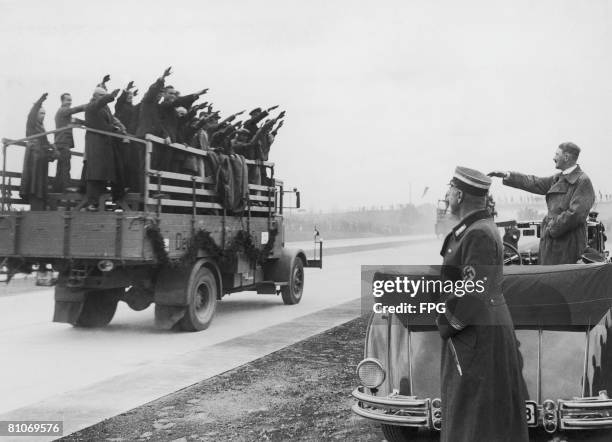 Nazi leader Adolf Hitler salutes a lorryload of construction workers as he opens a new 1000 km stretch of autobahn at Kostenblut, Lower Silesia,...