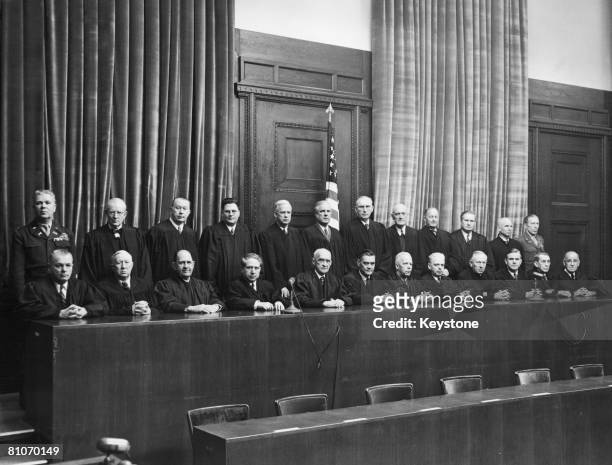 American judges of the OMGUS war crimes tribunals at the bench of the main courtroom in the in Nuremberg Palace of Justice, Germany, circa 1945....