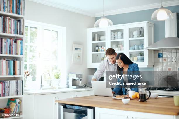 reading some reviews on restaurants to check out - couple in kitchen stock pictures, royalty-free photos & images