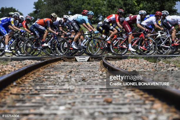 The pack cross rail tracks during the 187,5 km eighth stage of the 104th edition of the Tour de France cycling race on July 8, 2017 between Dole and...