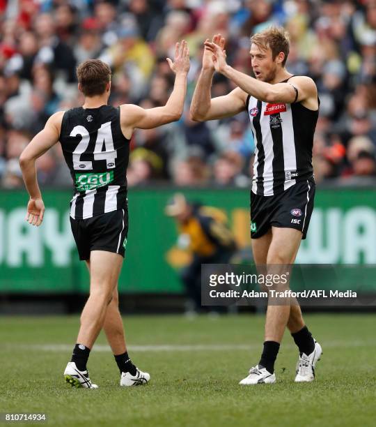 Ben Reid of the Magpies celebrates a goal with Josh Thomas of the Magpies during the 2017 AFL round 16 match between the Collingwood Magpies and the...