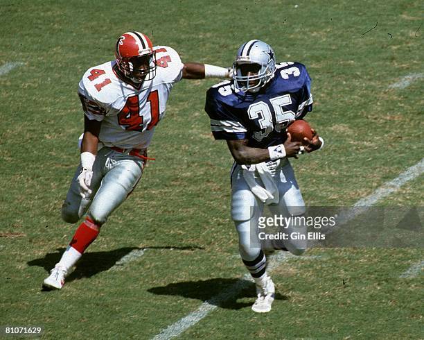 Running back Kevin Scott of the Dallas Cowboys tries to elude defensive back Tim Gordon of the Atlanta Falcons in Atlanta Fulton-County Stadium on...