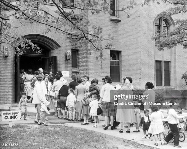 Children and parents line up outside the Children's Hospital to receive polio vaccines, Cincinnati, Ohio, April 24, 1960. The day marked to first day...