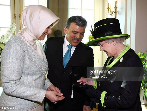 Britain's Queen Elizabeth II receives a gift from Turkey's first lady Hayrunisa Gul and Turkey's President Abdullah Gul at the presidential office on...