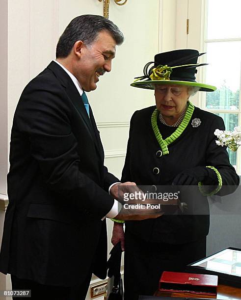 Britain's Queen Elizabeth II receives a gift from Turkey's President Abdullah Gul at the presidential office on May 13, 2008 in Ankara, Turkey. The...