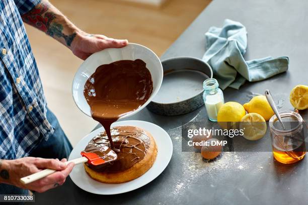 man hands putting icing on freshly baked cake - making a cake stock pictures, royalty-free photos & images