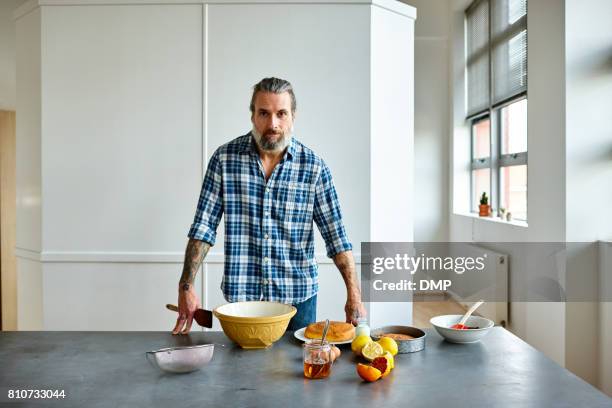 mittleren alter mann vorbereitung zum kuchenbasar - hipster in a kitchen stock-fotos und bilder