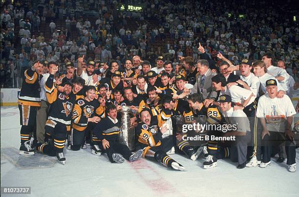 Team members and staff from the Pittsburgh Penguins ice hockey team pose together on the ice following their victory over the Minnesota North Stars...