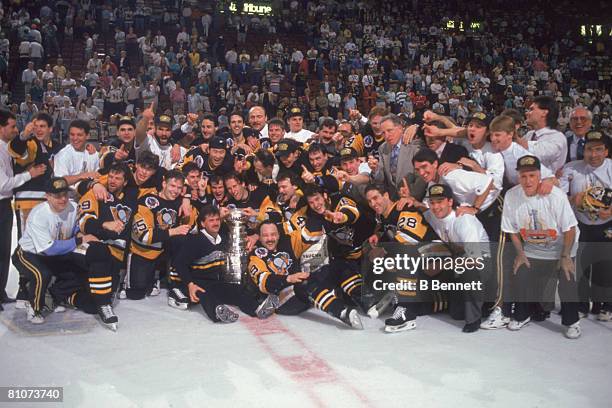 Team members and staff from the Pittsburgh Penguins ice hockey team pose together on the ice following their victory over the Minnesota North Stars...