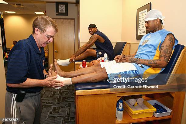 Allen Iverson and Carmelo Anthony of the Denver Nuggets get their ankles taped by athletic trainer Jim Gillen before Game Three of the Western...