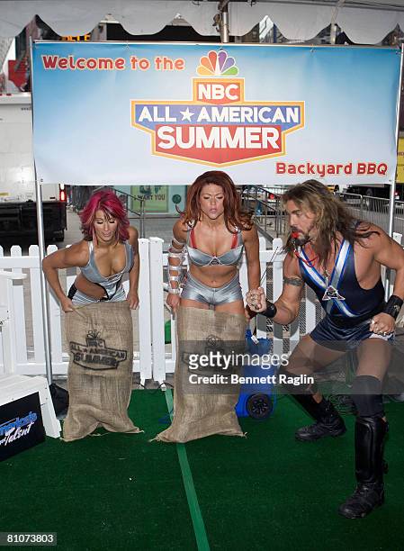 American Gladiators Jennifer "Phoenix" Widerstrom and Valerie "Siren" Waugaman compete in a potato sack race while Don "Wolf" Yates referees during...