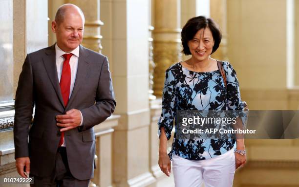 Hamburg's mayor Olaf Scholz greets the World Bank President's wife Younsook Lim as she arrives to attend the partners' programme at the city hall...