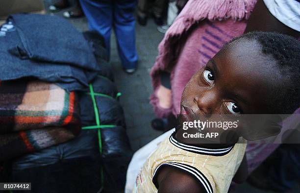 Young zimbabwean boy stands with his mother in a qeue to receive donated blankets by the African Red cross on May 13, 2008 outside the Alexandra...