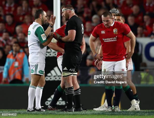 Romain Poite the referee, talks to All Black captain, Kieran Read after he reverses a decision when he orginally had awarded a penalty to the All...