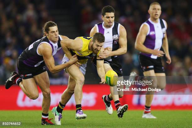 Jack Steele of the Saints and Leigh Montagna of the Saints tackle Kane Lambert of the Tigers during the round 16 AFL match between the St Kilda...