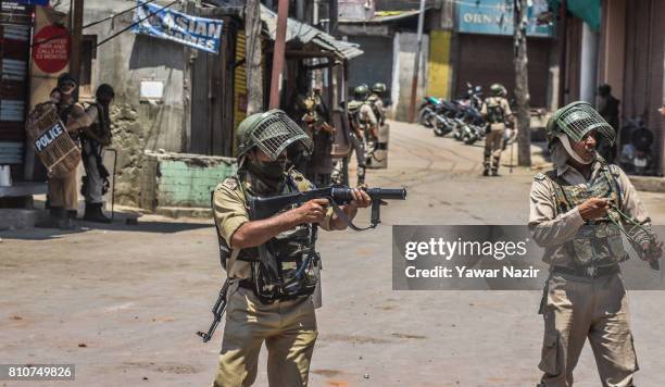 An Indian paramilitary trooper aims his tear gas rifle at Kashmiri Muslim protesters, during a protest after Kashmiri Muslims defied curfew, on the...