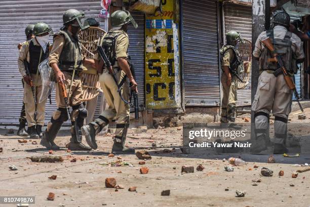 Indian government forces stand in the strewn stones thrown at them by Kashmiri Muslim protesters, during a protest after Kashmiri Muslims defied...