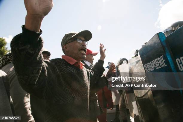 Man gestures in front of security forces as supporters of Madagascar's opposition party Tiako i Madagasikara take part in the party's 15th...
