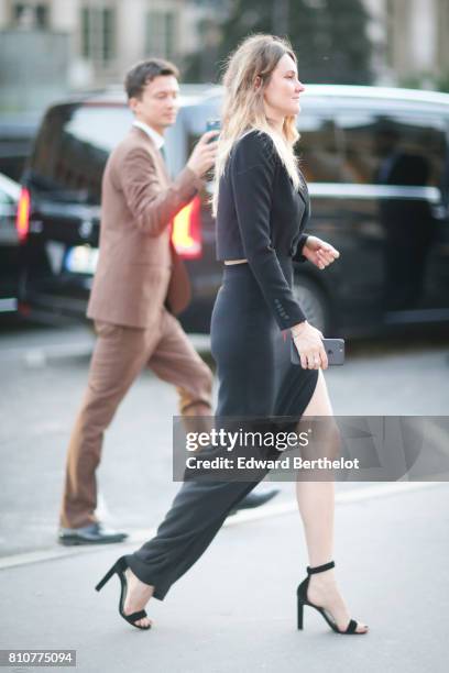 Guest wears a black dress and black heels shoes, outside the amfAR dinner at Petit Palais, during Paris Fashion Week - Haute Couture Fall/Winter...