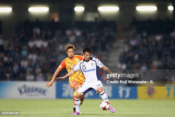 Jungo Fujimoto of Gamba Osaka controls the ball under pressure of Ko Matsubara of Shimizu S-Pulse during the J.League J1 match between Shimizu...