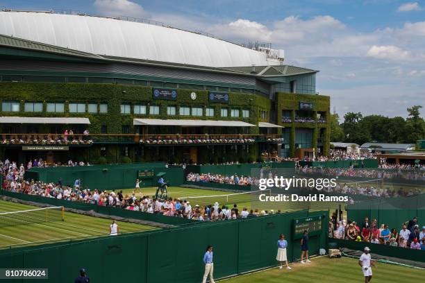 Tennis fans follow matches around the ouside courts on day six of the Wimbledon Lawn Tennis Championships at the All England Lawn Tennis and Croquet...