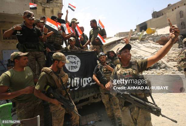 Members of the Iraqi federal police take a selfie in celebration in the Old City of Mosul on July 8 as their part of the battle has been declared...