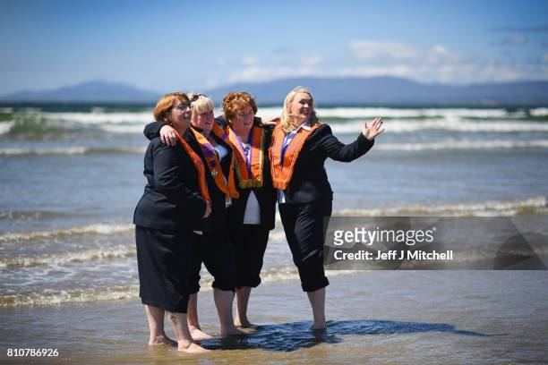 Sisters take a walk onto the beach as they take part in the annual pre Twelfth of July Orange parade held in Rossnowlagh on July 8, 2017 in Donegal,...