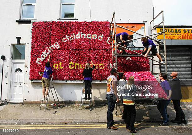 Workers put the finishing touches to the UK's first live flower billboard in Hackney on May 14, 2008 in London, England. The floral 20ft by 10ft...