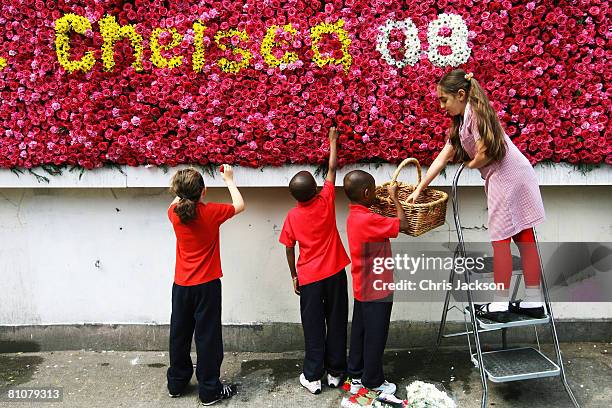 Sidal Durna, aged nine, is helped by her friends as she puts the finishing touches to the UK's first live flower billboard in Hackney on May 14, 2008...