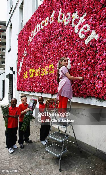 Sidal Durna, aged nine, is helped by her friends as she puts the finishing touches to the UK's first live flower billboard in Hackney on May 14, 2008...