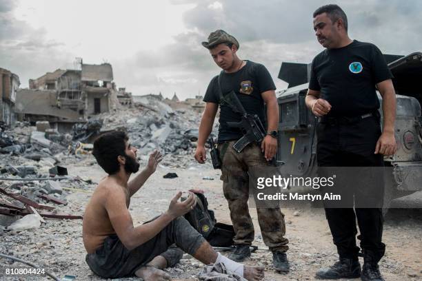 Iraqi Special Operation Forces soldiers interrogate a suspected Islamic State militant in the Old City district where heavy fighting continues on...