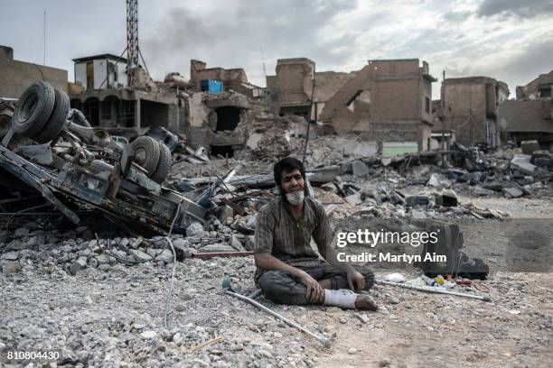 An injured Iraqi man who has been detained from among civilians and suspected of being an Islamic State militant by Iraqi forces cries in the...