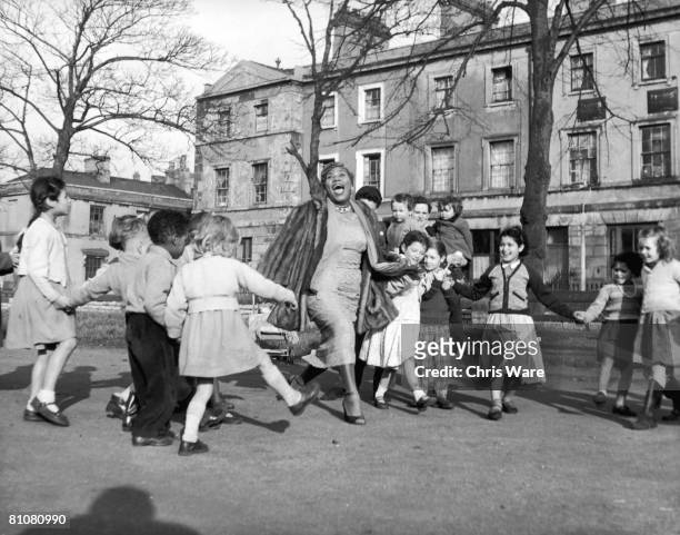 American gospel singer, songwriter and electric guitarist Sister Rosetta Tharpe with a group of children from the Tiger Bay area of Cardiff, 2nd...