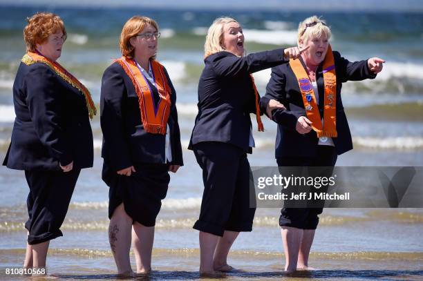 Sisters take a walk onto the beach as they take part in the annual pre Twelfth of July Orange parade held in Rossnowlagh on July 8, 2017 in Donegal,...