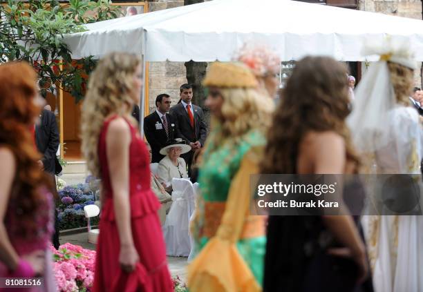 Britain's Queen Elizabeth II attends a banquet and fashion show at a silk market with Turkish designer Rifat Ozbek in Turkey's northwest city of...