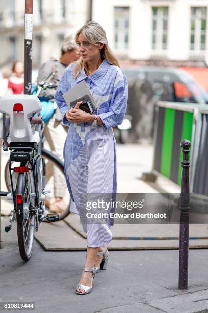 Guest wears a blue and white dress, silver shoes, outside the Elie Saab show, during Paris Fashion Week - Haute Couture Fall/Winter 2017-2018, on...