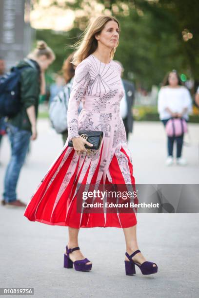 Guest wears a pink dress with red lines, purple shoes and a Gucci bag, outside the amfAR dinner at Petit Palais, during Paris Fashion Week - Haute...