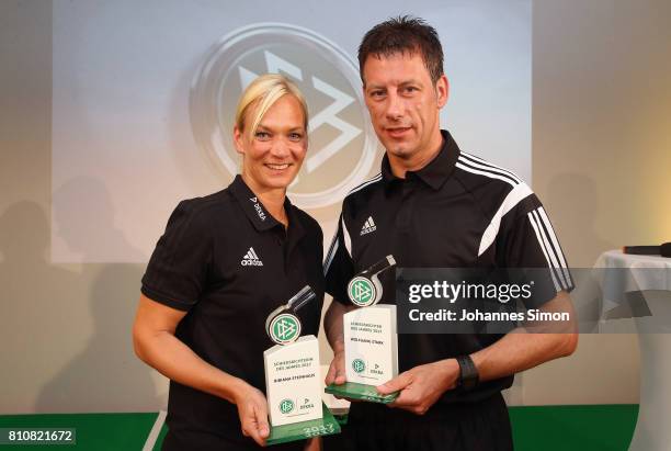 Referees Bibiana Steinhaus and Wolfgang Stark pose with the award trophy after been awarded as referee of the year 2017 on July 8, 2017 in Grassau,...